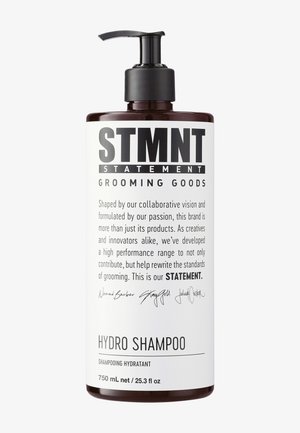 Flacon de shampooing STMNT Hydro avec pompe noire, étiquette blanche comprenant la description du produit, la marque des produits de toilettage, et une information de volume de 750 ml.