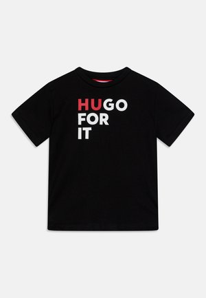 Schwarzes T-Shirt mit kurzen Ärmeln und dem Text "HUGO FOR IT" in fetten Buchstaben auf der Vorderseite, "HU" in Rot und der Rest in Weiß.