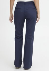 Navy blue trousers with a straight-leg design, featuring two back pockets and a smooth, textured fabric. Suitable for various occasions.