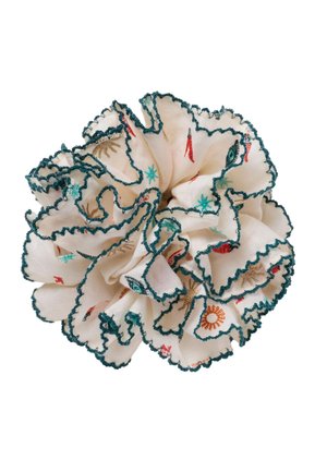 Flødefarvet stof scrunchie med grønne bølgede kanter og små farverige broderede motiver af chilipebre og sole.
