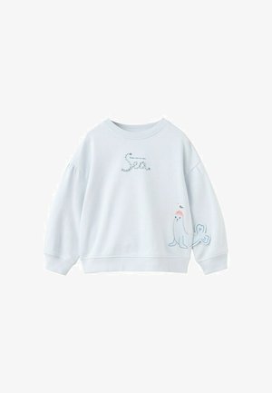 Witte sweatshirt met lange mouwen met de tekst "Neem me mee naar de zee" en een zeehond die een roze hoed draagt met een vogel op zijn kop, vlak bij de zoom.