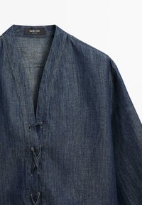 Veste en jean avec large col et fermeture avant à lacets croisés en tissu bleu foncé de Massimo Dutti.