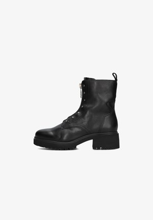 Zwarte leren enkelboot met een ronde neus, decoratieve oogjes, zijrits, gestructureerd ontwerp en chunky zool met profiel.