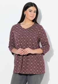 Burgunderfarbener, gemusterter Oberteil mit V-Ausschnitt, dreiviertel Ärmeln und kreisförmigen Designs in einer helleren Farbe, aus einem weichen Stoff gefertigt.