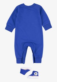 Macacão de algodão azul para bebé com mangas longas, punhos canelados e decote redondo. Inclui botinhas de desporto mini azuis com detalhes brancos.