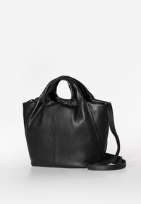 Zwarte leren tote bag met een gestructureerde afwerking, gebogen handvatten en een afneembare schouderband. Heeft naden voor een gestructureerde vorm.