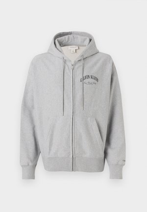 Ανοιχτό γκρι φούτερ με φερμουάρ, τσέπες μπροστά, κουκούλα με ρυθμιζόμενο κορδόνι και το κείμενο "Calvin Klein New York City" στο αριστερό στήθος.