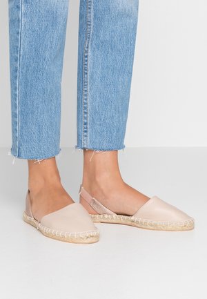 Světlé růžové kožené espadrilky s opletenou podešví z juty, mírně otevřeným designem paty a kovovým páskem na zadní straně.