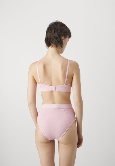 Rózsaszín bordázott bralette és magas derekú alsónemű szett állítható pántokkal és akasztós záródással, sima textúrával és varrási részletekkel.
