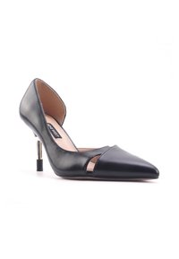 Chaussure à talon haute en cuir noir avec un bout pointu, des découpes ouvertes sur les côtés et un accent en chrome métallique sur le talon. Texture lisse.