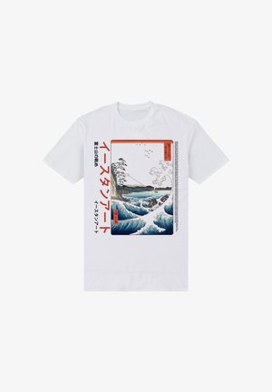 Camiseta blanca de algodón con un diseño impreso de olas y montañas en azul y blanco, con detalles de texto japonés en rojo y negro.