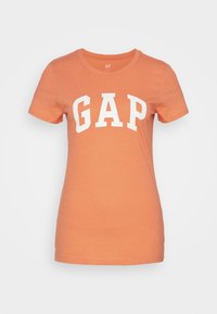 T-shirt à manches courtes et col rond en tissu orange au toucher doux. Doté d'un grand logo "GAP" blanc sur la poitrine.