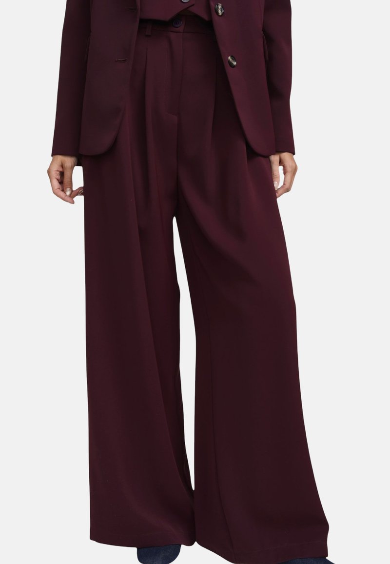 Pantaloni bordeaux a gamba larga in tessuto liscio, con vita alta, pieghe frontali e due tasche laterali.