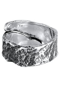 Hopeinen sormus, jossa on teksturoitu ja orgaaninen muotoilu. Sen ominaisuuksia ovat sileä, kaareva sormi ja karkeat, epätasaiset yksityiskohdat. Merkitty "925" sterlinghopeaksi.