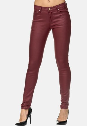 Pantalons skinny en simili cuir bordeaux avec une taille basse, design à cinq poches et bouton en métal argenté. Texture lisse et forme ajustée.