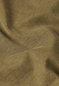 Tessuto khaki con una fine trama a maglia, caratterizzato da morbide cadute e una lucentezza sottile, creando una superficie liscia e uniforme su tutto il materiale.