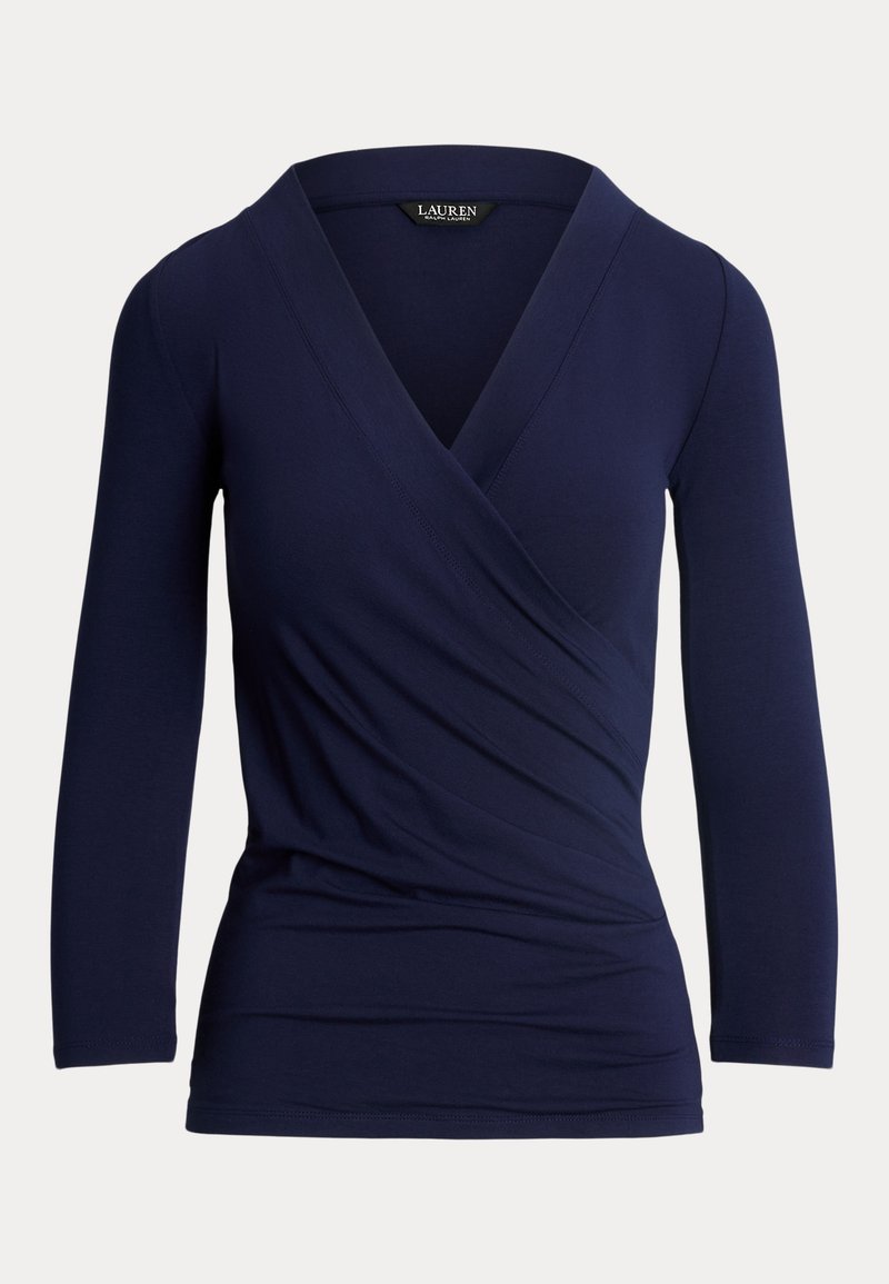 Σκούρο μπλε μπλούζα με μακριά μανίκια και σχέδιο τύπου περιτυλίγματος, v-λαιμόκοψη και μαλακή υφή. Διαθέτει ραφή στο μπροστινό μέρος και εφαρμοστή σιλουέτα.