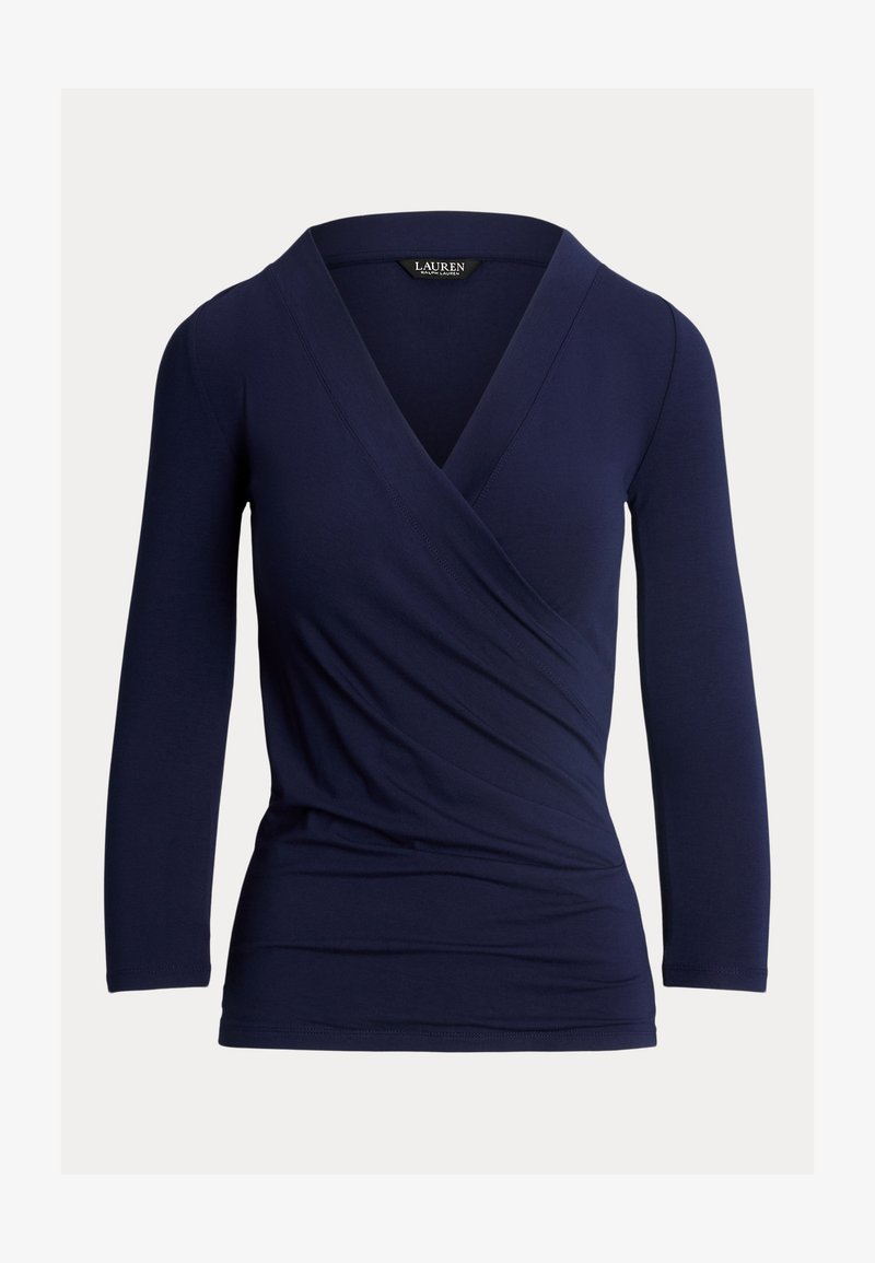 Tamsiai mėlynos spalvos ilgomis rankovėmis palaidinė su surišimo dizainu, V formos iškirpte ir minkštu tekstūru. Pabrėžia raukšlių detales priekyje ir prigludusią siluetą.