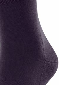 Fioletowa skarpetka do kostek o gładkiej, żebrowanej fakturze i wzmocnionym pięcie. Charakteryzuje się dopasowanym krojem i bezszwową konstrukcją.