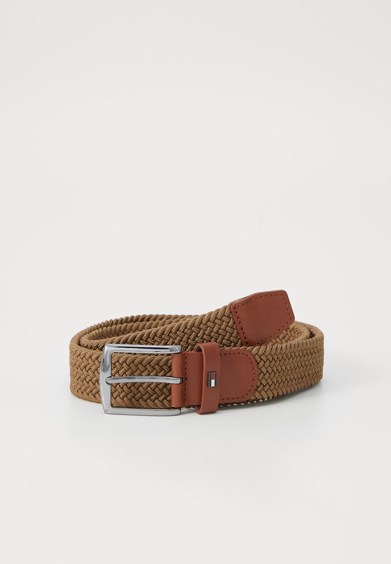 Ceinture tressée en beige avec une sangle en cuir lisse beige, une boucle en métal argenté et un accent logo sur le cuir pour le détail.
