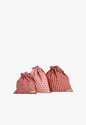 Tres bolsas de tela con cordón en rosa y rojo con estampados pequeños de leopardo, pequeños corazones y rayas verticales sobre fondo blanco.