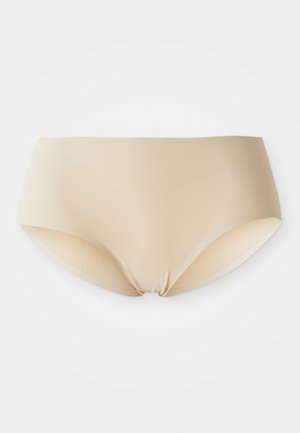 Brezšivne ženske hipster hlačke v nude barvi, razprte na beli podlagi, gladko blago brez vidnih šivov ali vzorcev.