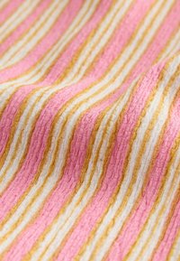Tessuto con righe rosa e bianche, accentuato da oro. Stoffa morbida e testurizzata con un aspetto ondulato, che mette in risalto i colori contrastanti.