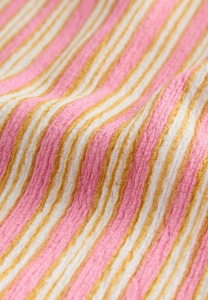 Tekstylia w różowo-białe paski, akcentowane złotem. Miękka, strukturalna tkanina o falistej powierzchni, podkreślająca kontrastujące kolory.