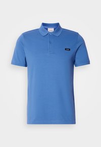 Polo bleu à manches courtes avec deux boutons et un petit écusson logo Calvin Klein noir sur la poitrine gauche.