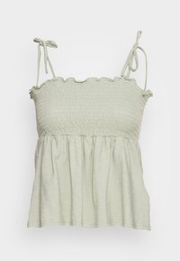 Top sin mangas de color verde claro, con cuerpo acanalado, escote con volantes y tirantes ajustables; presenta un dobladillo fluido y recogido.