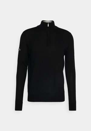 Schwarzer Pullover mit langen Ärmeln, hohem Kragen und halbseitigem Reißverschluss. Verfügt über gerippte Ärmelbündchen und Saum, hergestellt aus einem weichen, strukturierten Strickstoff.
