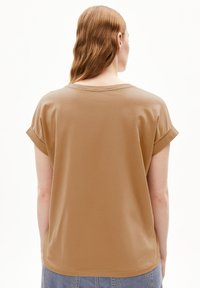 Braunes Kurzarm-T-Shirt mit lässiger Passform, Rundhalsausschnitt und aufgerollten Ärmeln, aus weichem Stoff gefertigt. Glatte Textur in einfarbiger Ausführung.