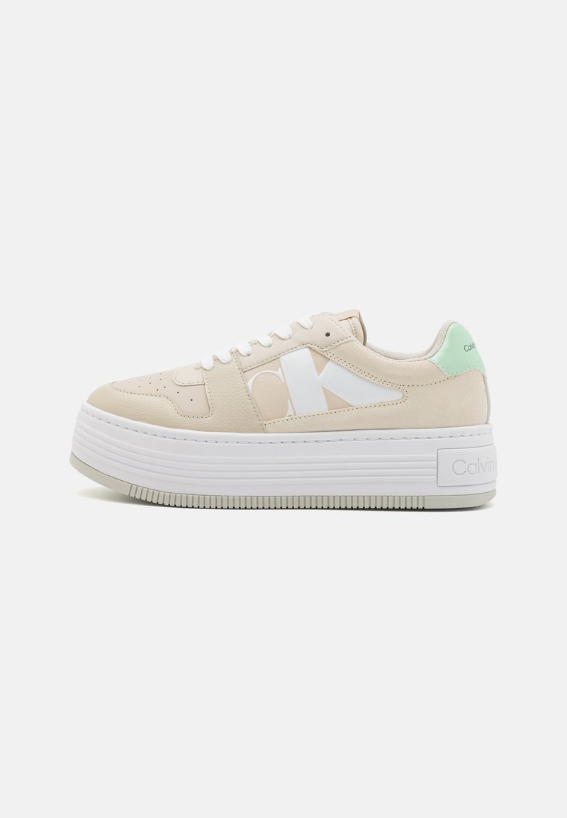 Sneaker platform Calvin Klein con tomaia sintetica beige, branding bianco e accento verde menta sul tallone. Suola in gomma testurizzata.