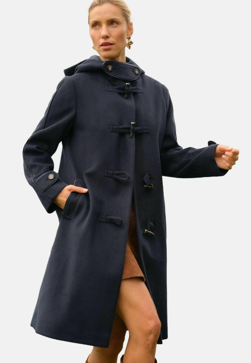 Cappotto in misto lana navy con chiusure a nodi, cappuccio, grandi tasche e maniche larghe; lunghezza al ginocchio con una silhouette dritta.