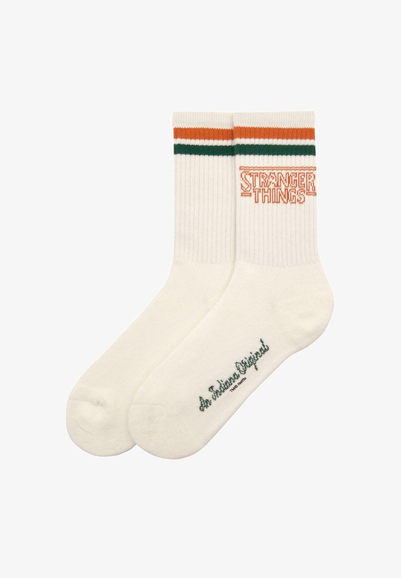 Białe skarpetki bawełniane z pomarańczowymi i zielonymi paskami na górze. "STRANGER THINGS" jest wyhaftowane na pomarańczowo. Miękka tekstura, długość do kostki.