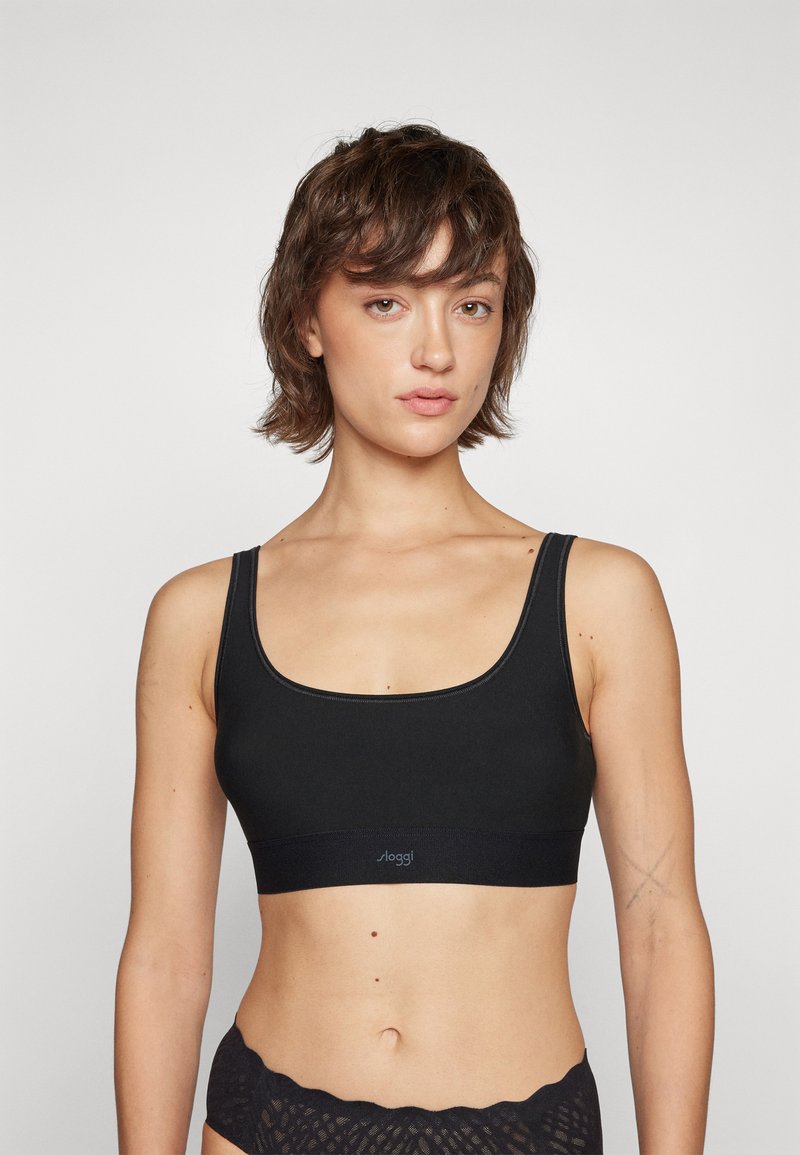 Soutien-gorge de sport noir avec un décolleté en U et des bretelles larges. Fabriqué en tissu lisse avec un logo sur la bande. Design simple et sans coutures.