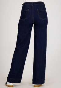 Wijdvallende jeans in donkerblauwe denim, met een hoge taille, twee achterzakken en zichtbare stiksels langs de naden.