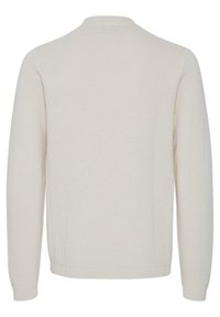 Lys beige strikket genser med rund hals, lange ermer og et teksturert mønster. Ribbestrikkede mansjetter og hem gir et estetisk løft til designet.