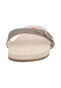 Light wooden platform sandal with a brown leather strap and silver buckle, featuring a flat sole and minimalistic design.