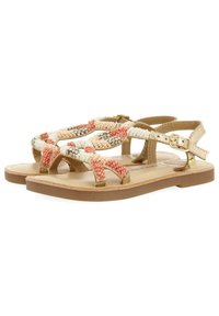 Sandalias de cuentas con un patrón multicolor de cuentas blancas, coral y durazno; correas en color tostado; y una suela marrón clara con herrajes de hebilla simples.