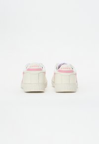 Baskets en cuir blanc avec des accents roses et un logo sur le talon, dotées d'une semelle en caoutchouc texturé et d'un col rembourré pour plus de confort.
