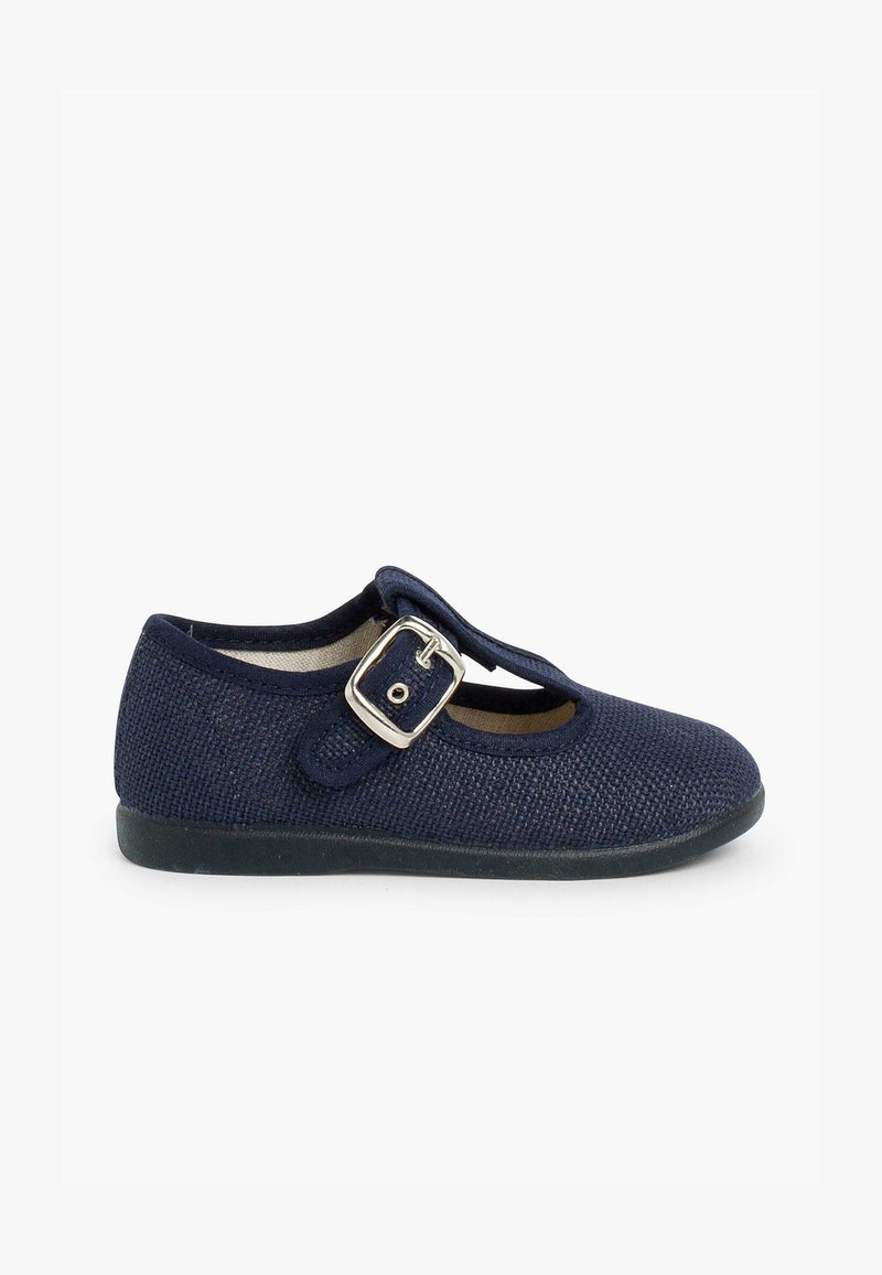 Zapato Mary Jane azul marino con textura trenzada, correa con hebilla, punta redonda y suela flexible de goma negra. Presenta un diseño con recortes.