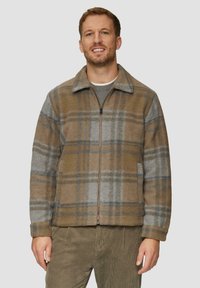 Bruin en grijs geruite fleece jack met rits, hals en zijzakken. Heeft een relaxte pasvorm en subtiele blauwe accenten.