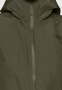 Veste à capuche vert olive avec une fermeture éclair centrale et le logo The North Face sur la poitrine.