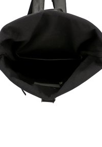 Zwarte tote bag met een stoffen buitenkant en leren handvatten, met een ruime binnenkant en een enkele gestikte pocket aan de binnenzijde.
