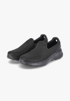 Black slip-on shoes made of mesh fabric feature a textured surface, cushioned sole, and rounded toe design, providing a lightweight fit.