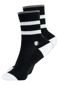 Calzini a righe bianche e nere con un risvolto grigio, caratterizzati da un piccolo logo ricamato sul lato. Realizzati in un morbido materiale lavorato a maglia.