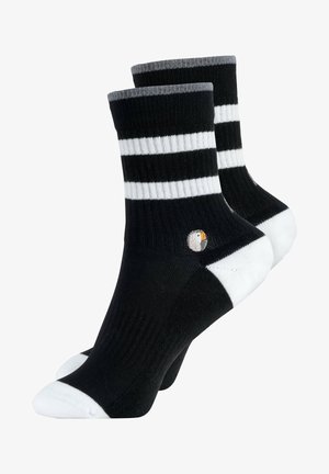 Valkoiset ja mustat raidalliset sukat harmaalla resorilla, joissa on pieni brodeerattu logo sivussa. Valmistettu pehmeästä neulotusta materiaalista.