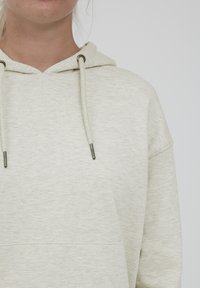 Helle graue, weiche Kapuzenjacke aus texturiertem Stoff mit einer Fronttasche, Kordelzugkapuze und runden Metallösen.