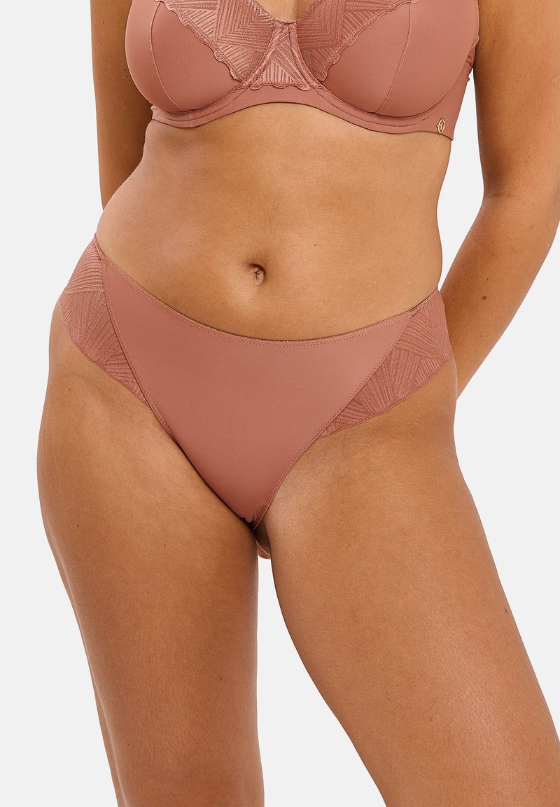Ensemble de soutien-gorge et culotte assortis de couleur marron, présentant un tissu lisse, des détails en dentelle géométrique et un ourlet à bords festonnés sur la culotte.